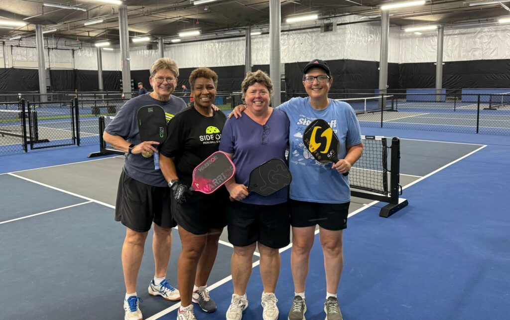 Four pickleball players at indoor court