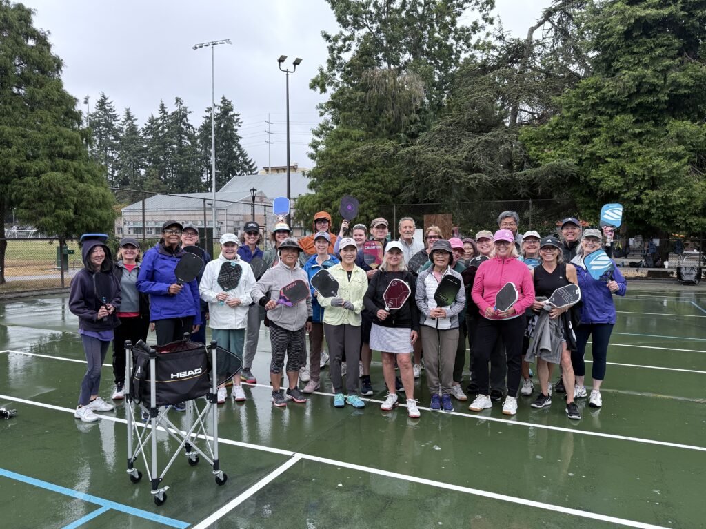 group of pickleball players on a wet outdoor court