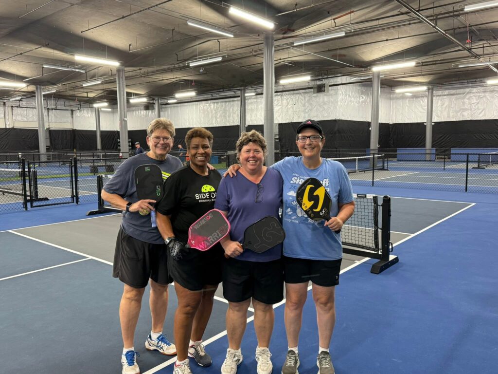Four pickleball players at indoor court